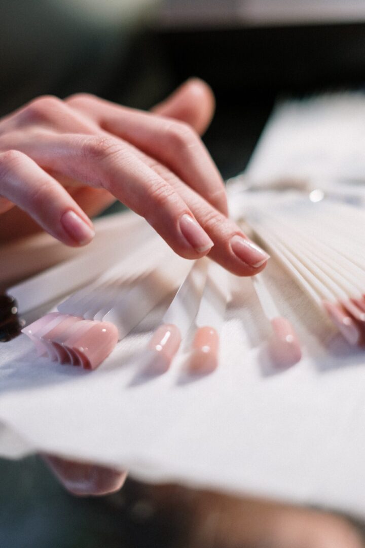 A person is putting their nails on top of paper.